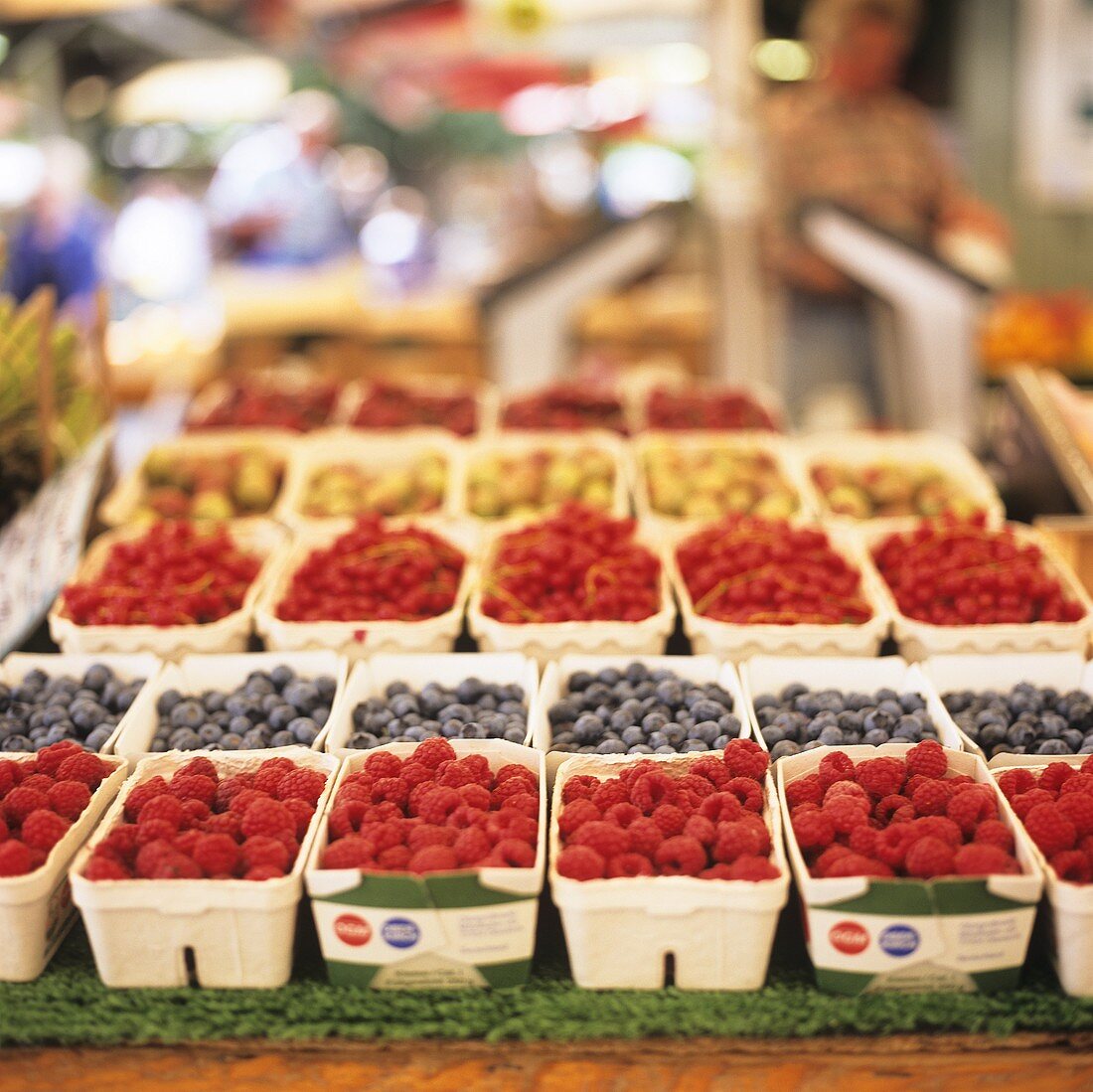 Himbeeren, Heidelbeeren, etc. in Pappschälchen auf dem Markt