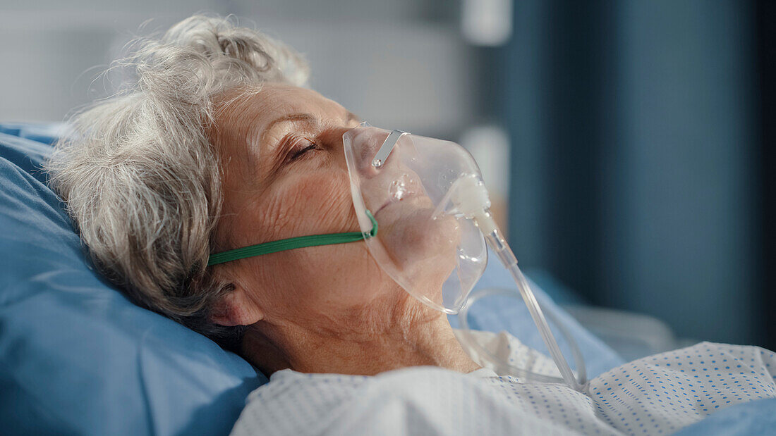 Elderly patient sleeping wearing oxygen mask