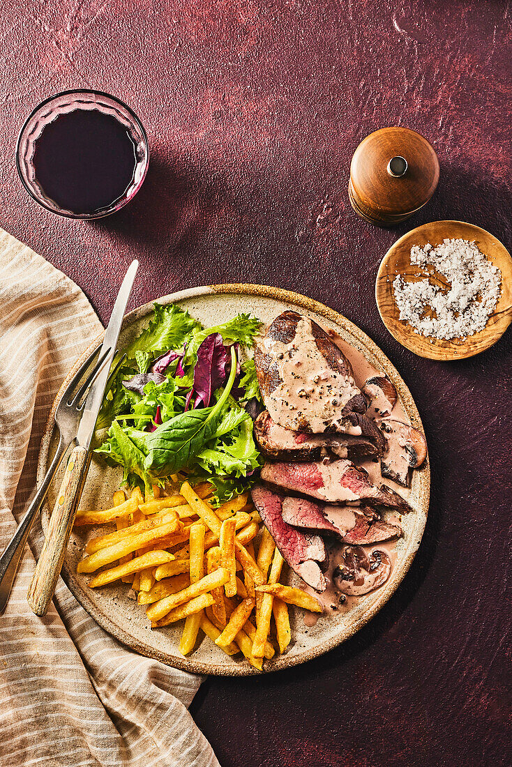 Game steaks with mushroom and pepper sauce and French fries