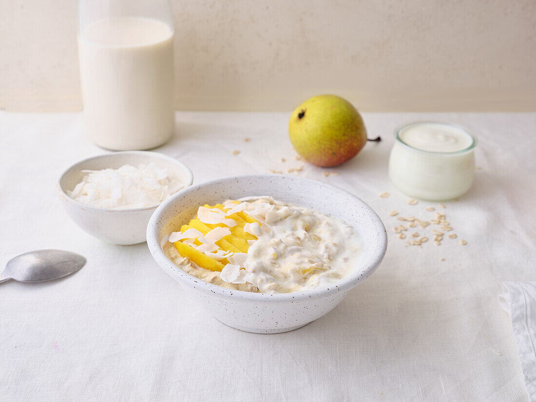 Overnight oats with yoghurt, mango and coconut flakes