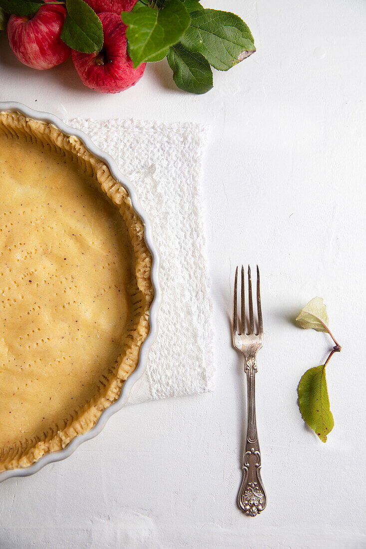 Unbaked shortcrust pastry base with fresh apples