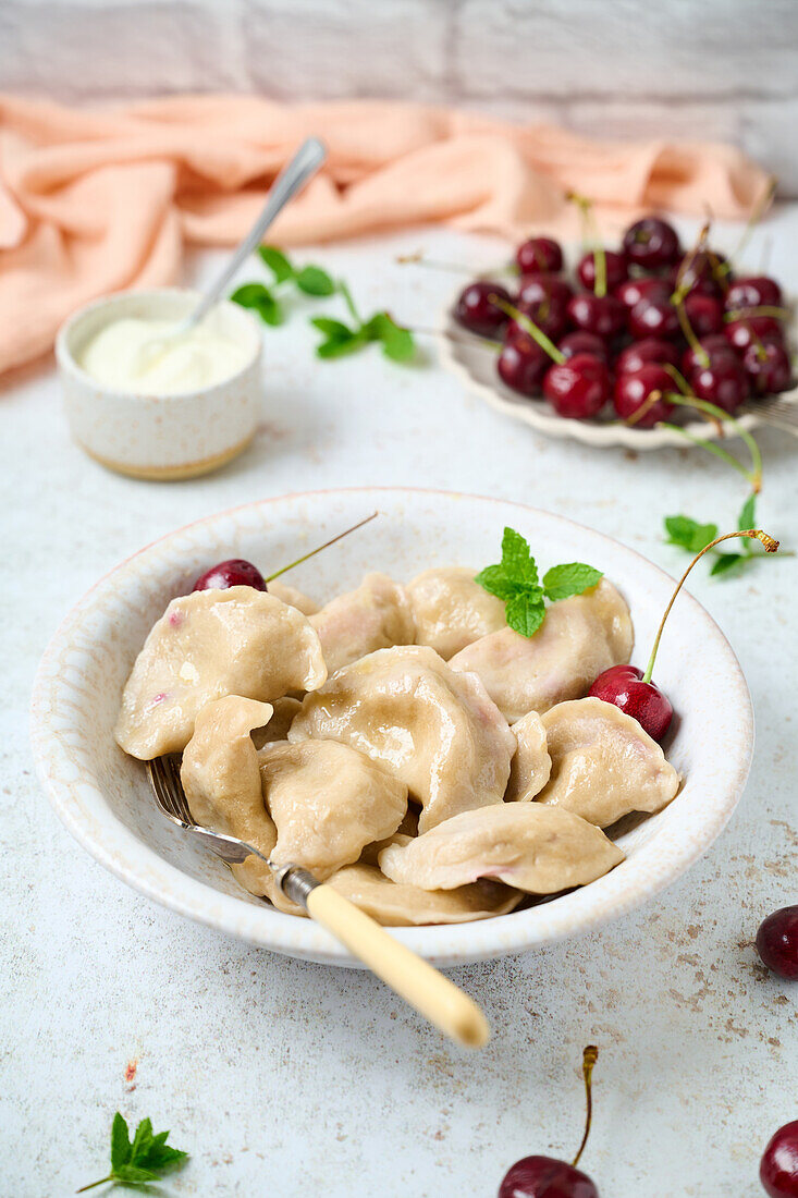 Sauerkirsch-Pierogi mit frischen Kirschen und geschmolzener Butter