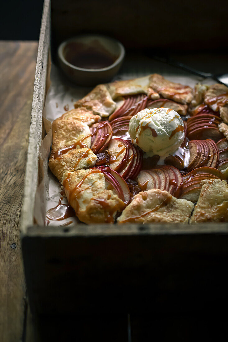 Apfel-Galette mit einer Kugel Vanilleeis und Karamellsauce