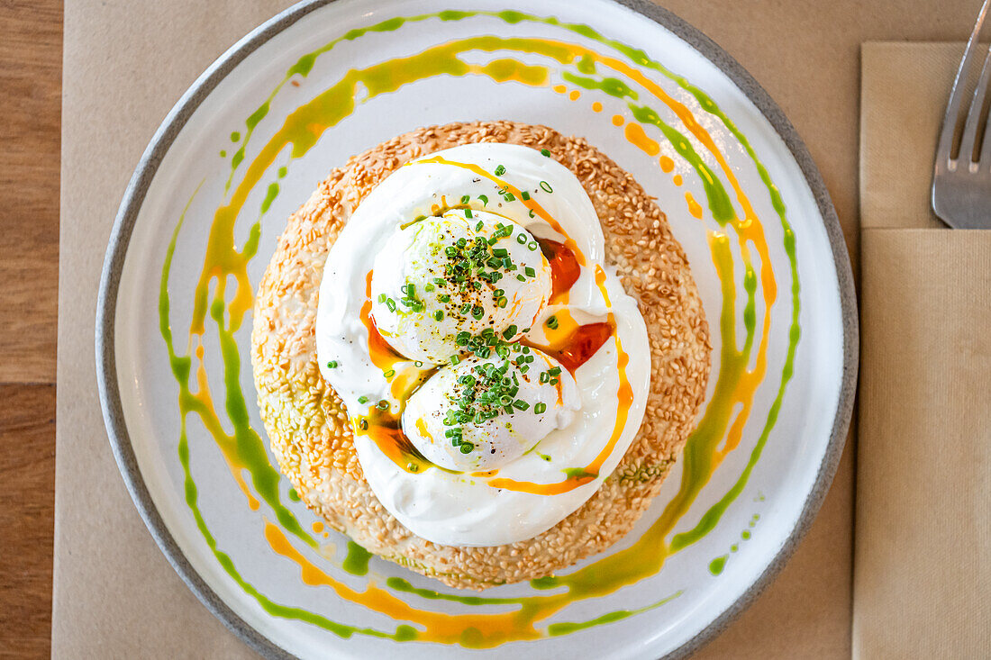 Pochierte Eier mit Joghurt auf Sesambagel