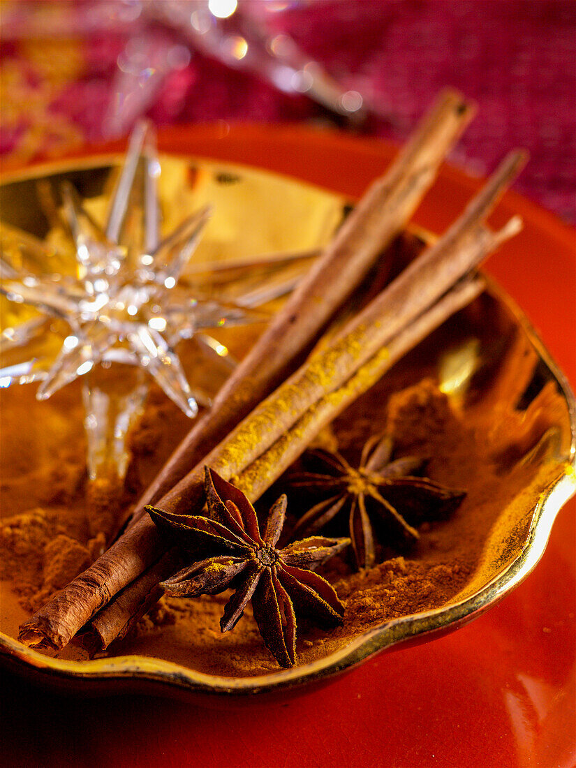 Star anise and cinnamon sticks on a golden plate