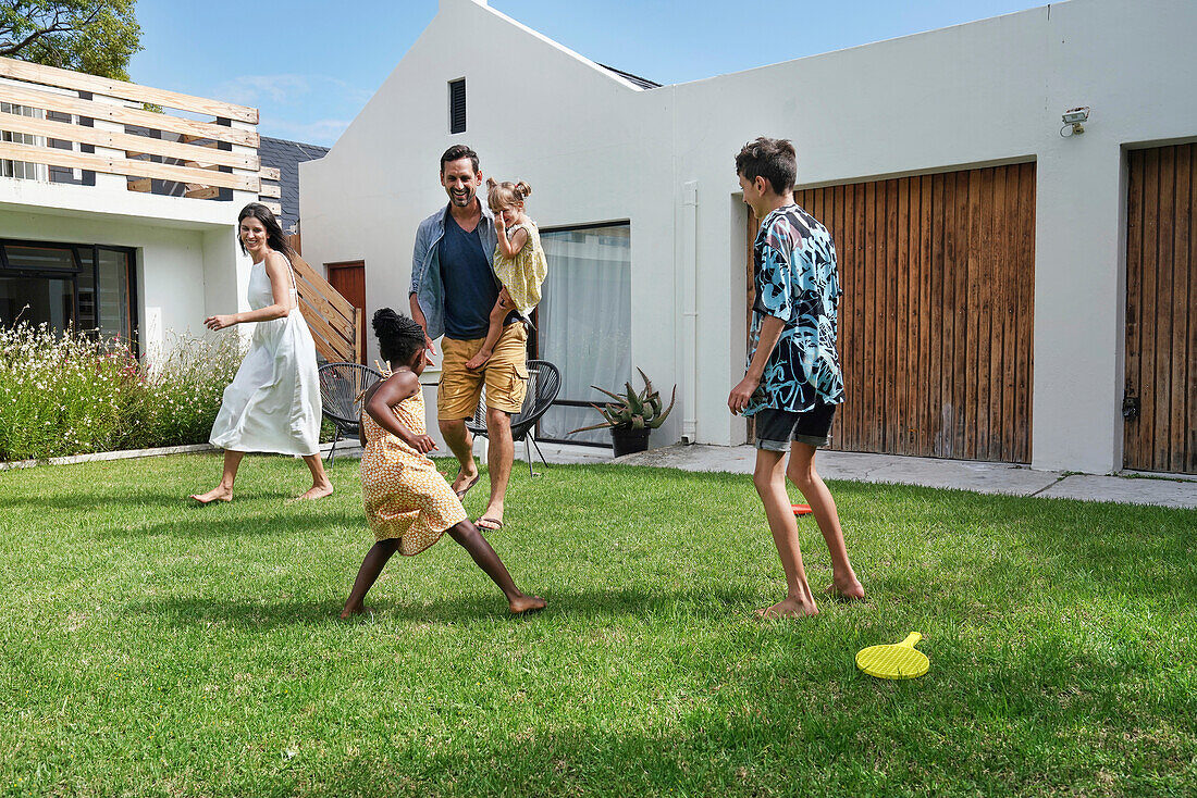 Parents with children playing in backyard