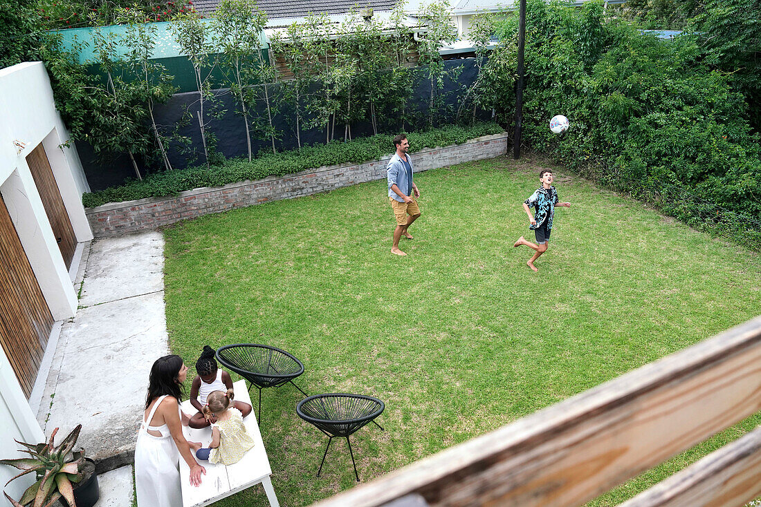 Parents with children playing in backyard