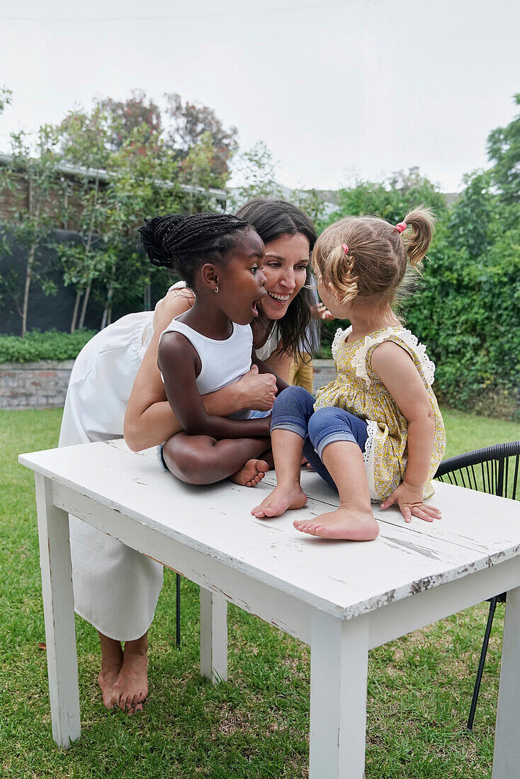 Mother with daughters playing in backyard