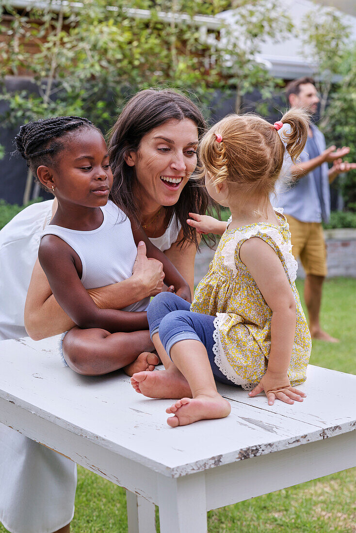 Mother with daughters playing in backyard