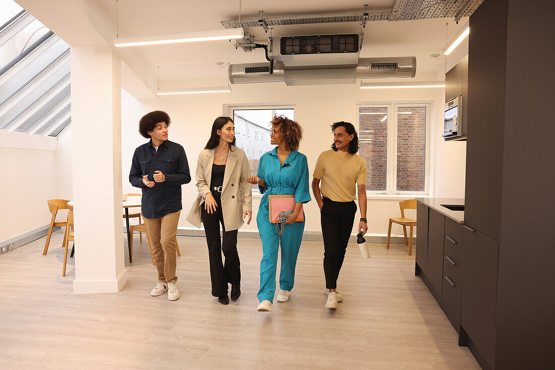 Smiling colleagues walking in modern creative studio