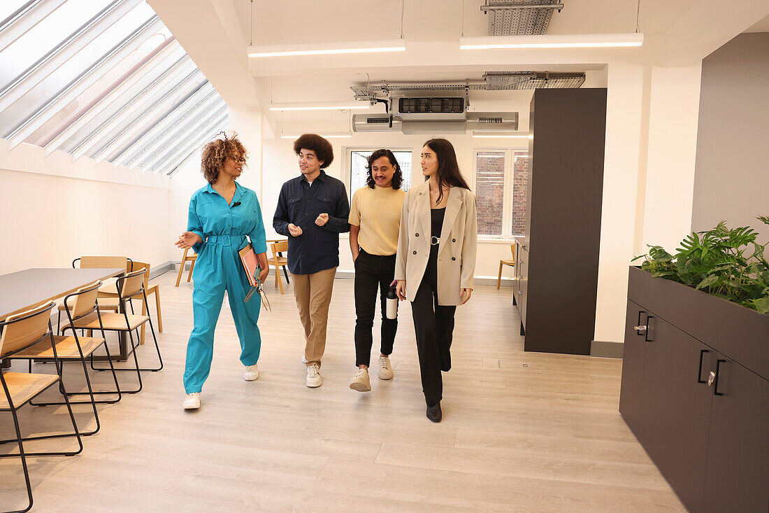 Smiling colleagues walking in modern creative studio