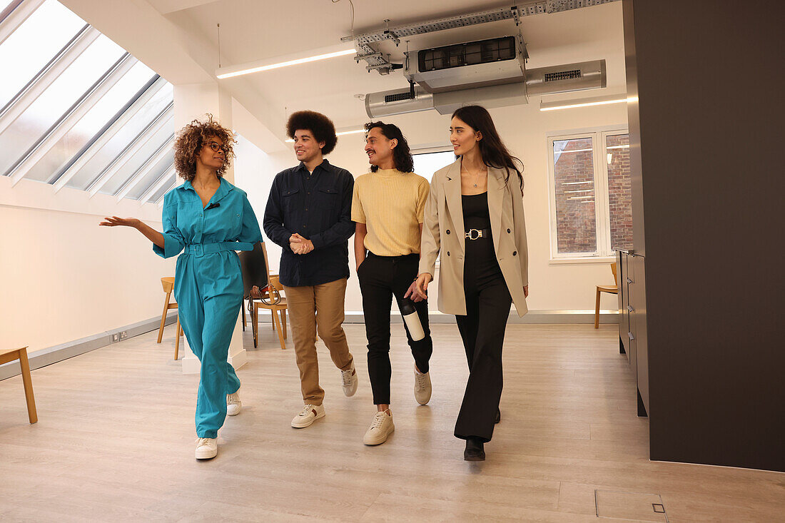 Smiling colleagues walking in modern creative studio