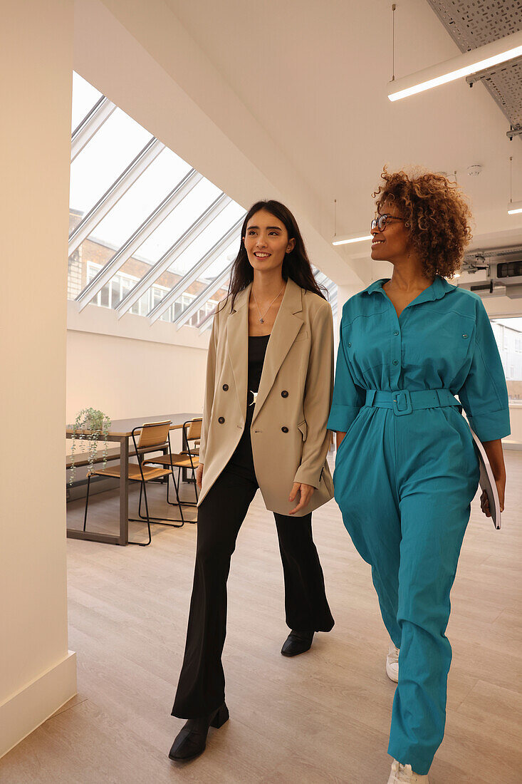 Two businesswomen walking in modern office