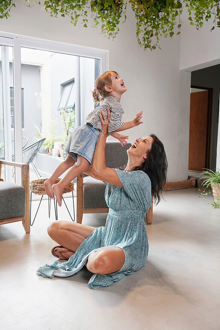 Woman playing with daughter at home