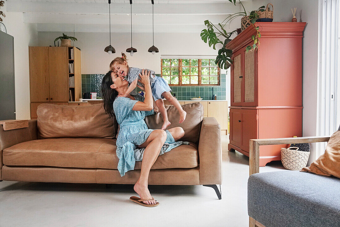 Woman playing with daughter at home