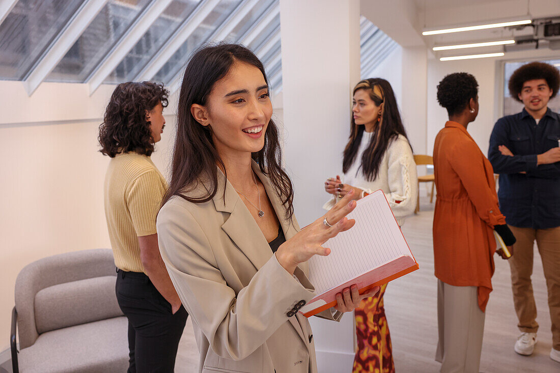 Employee holding notebook during team meeting