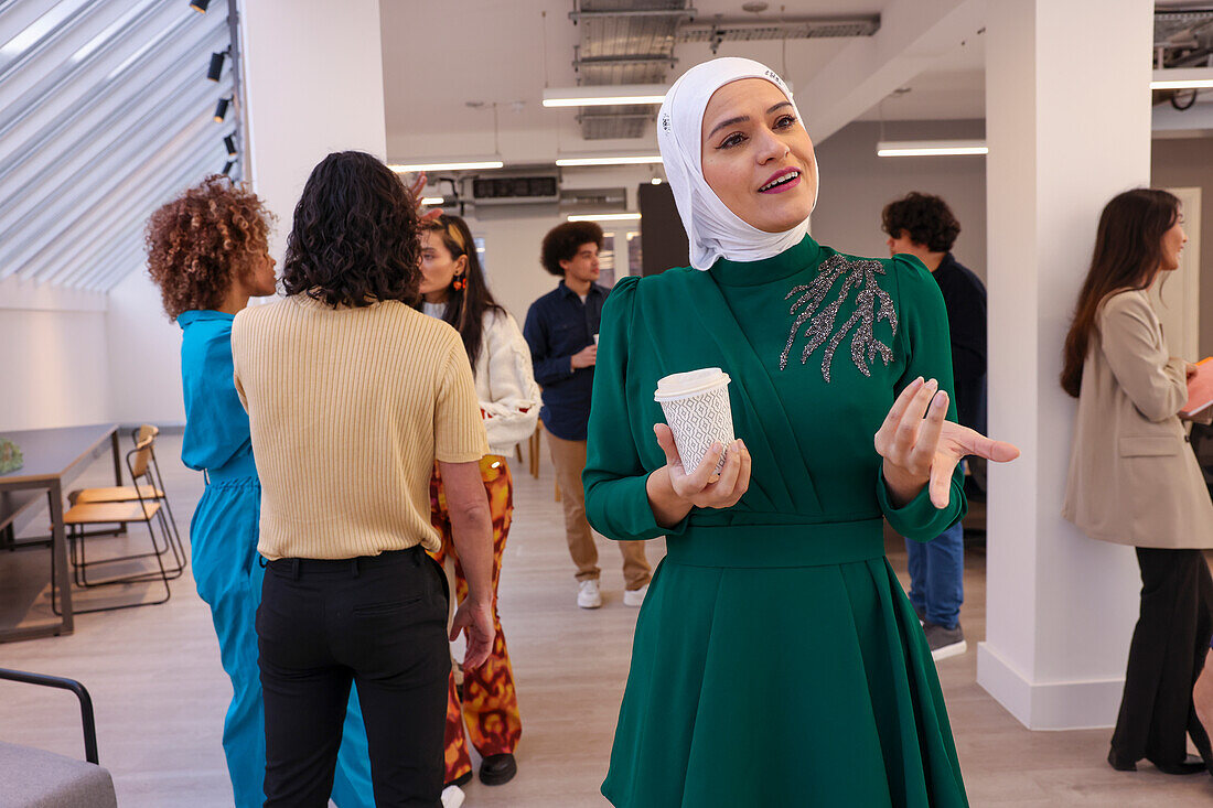 Employee holding coffee during team meeting