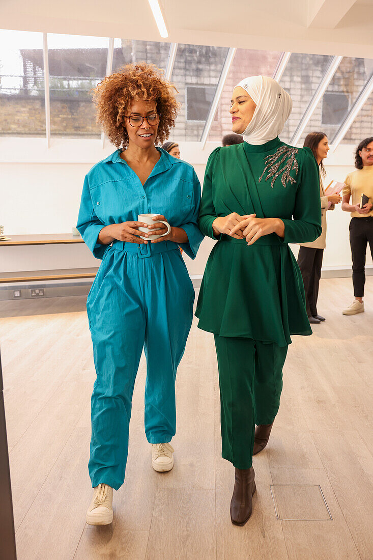 Employees walking and talking in office