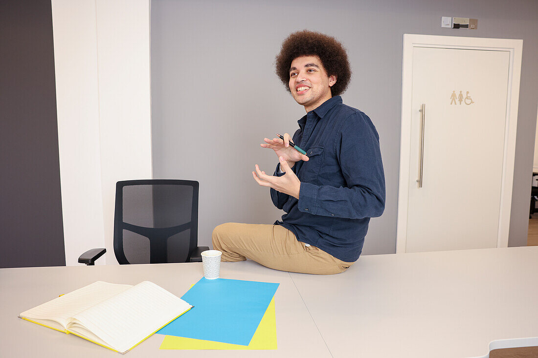 Employee sitting on desk in office