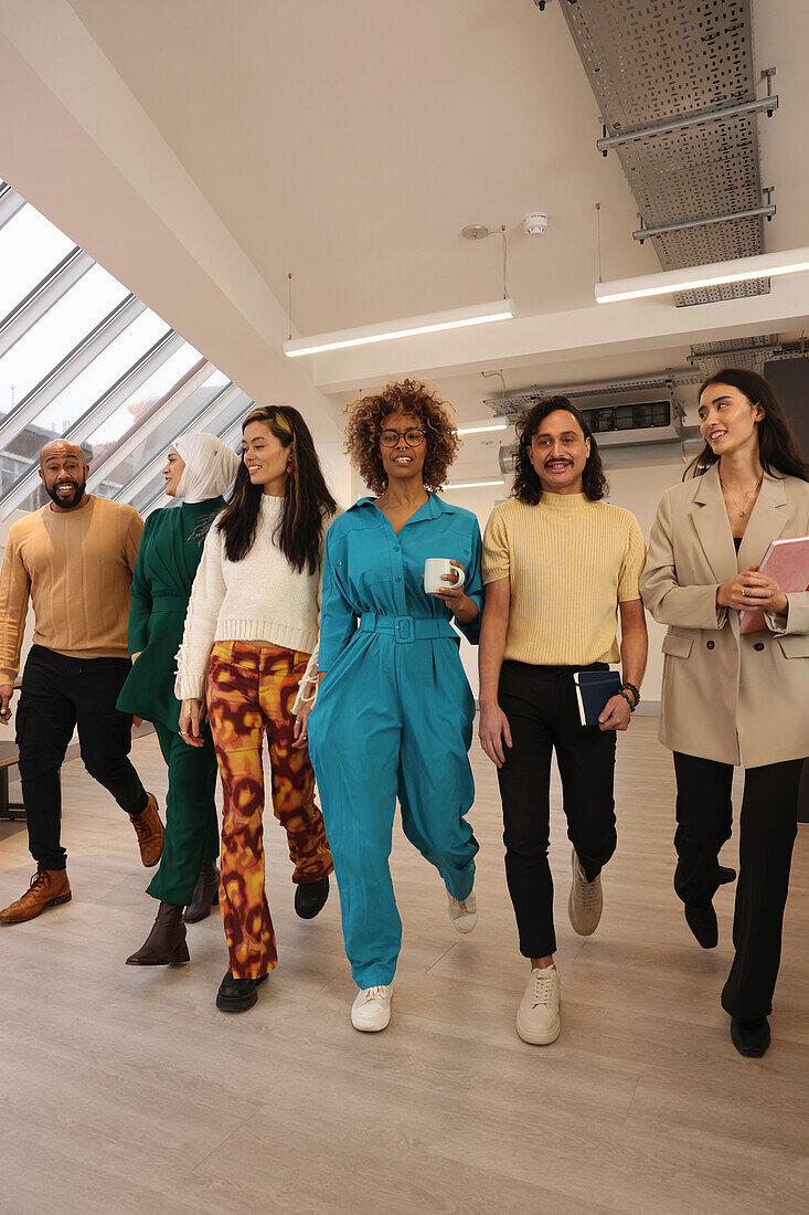 Smiling creative workers walking in office