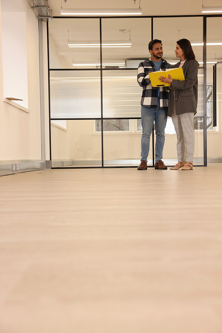 Coworkers talking in empty office