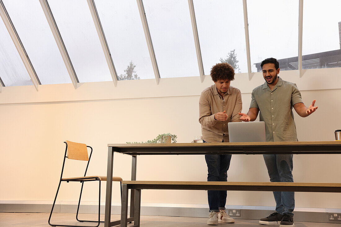 Coworkers looking at laptop in office