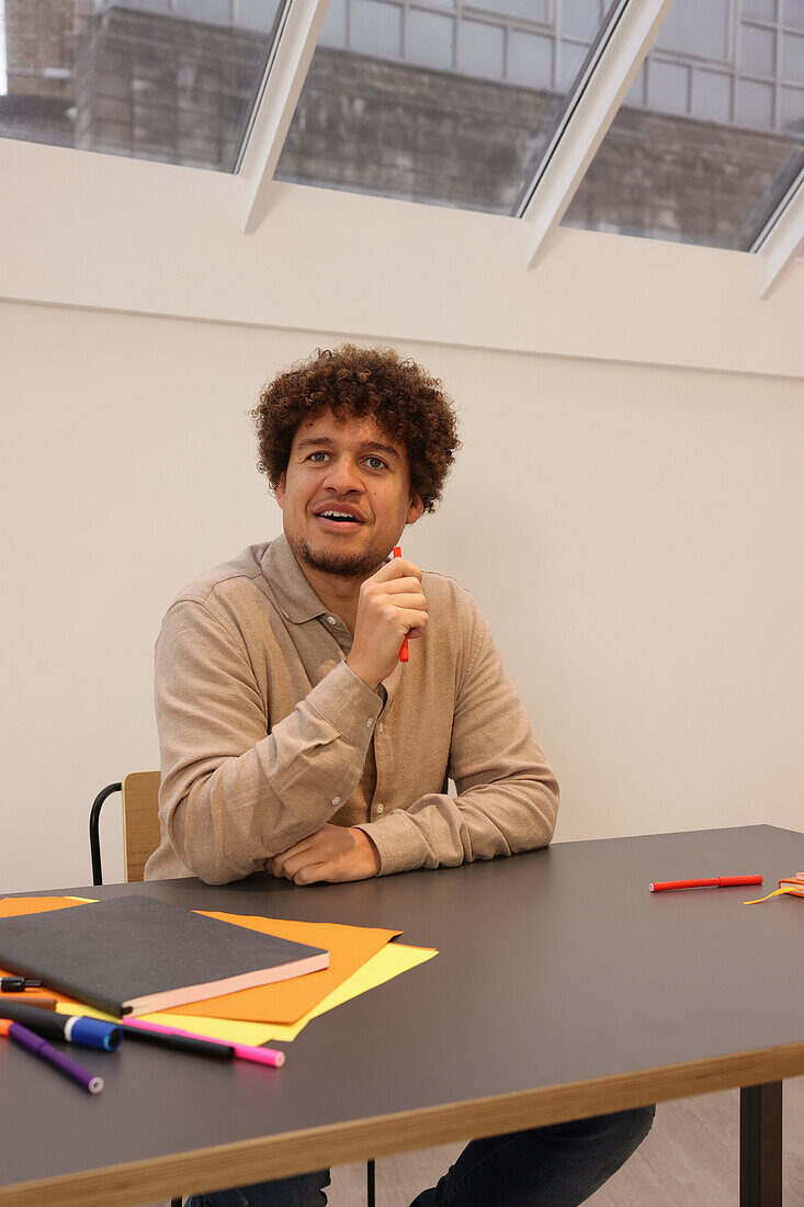 Smiling man sitting at table in office