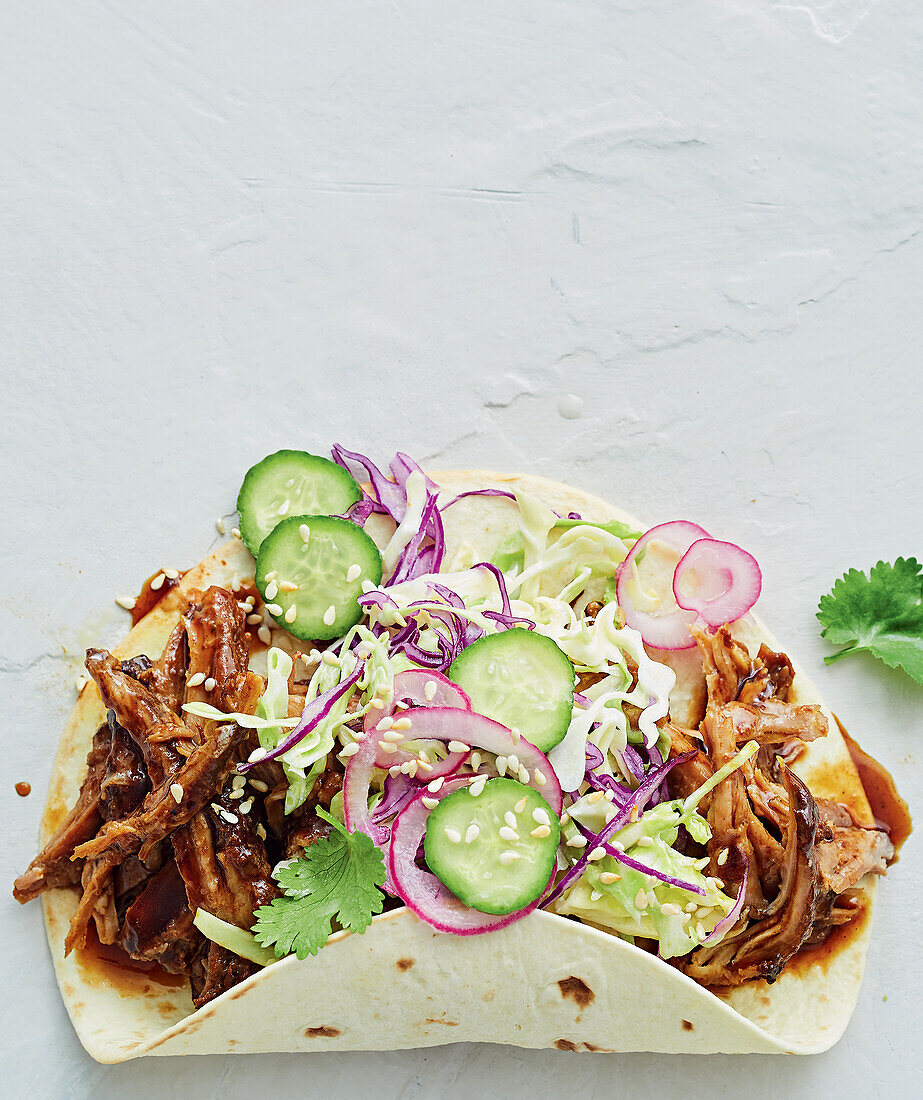 Pulled pork tacos with vegetables and sesame seeds