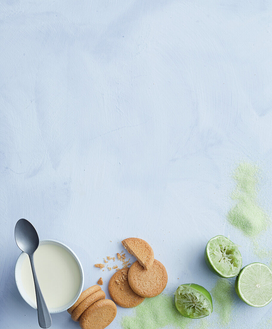 Biscuits, lime and milk on a light blue background