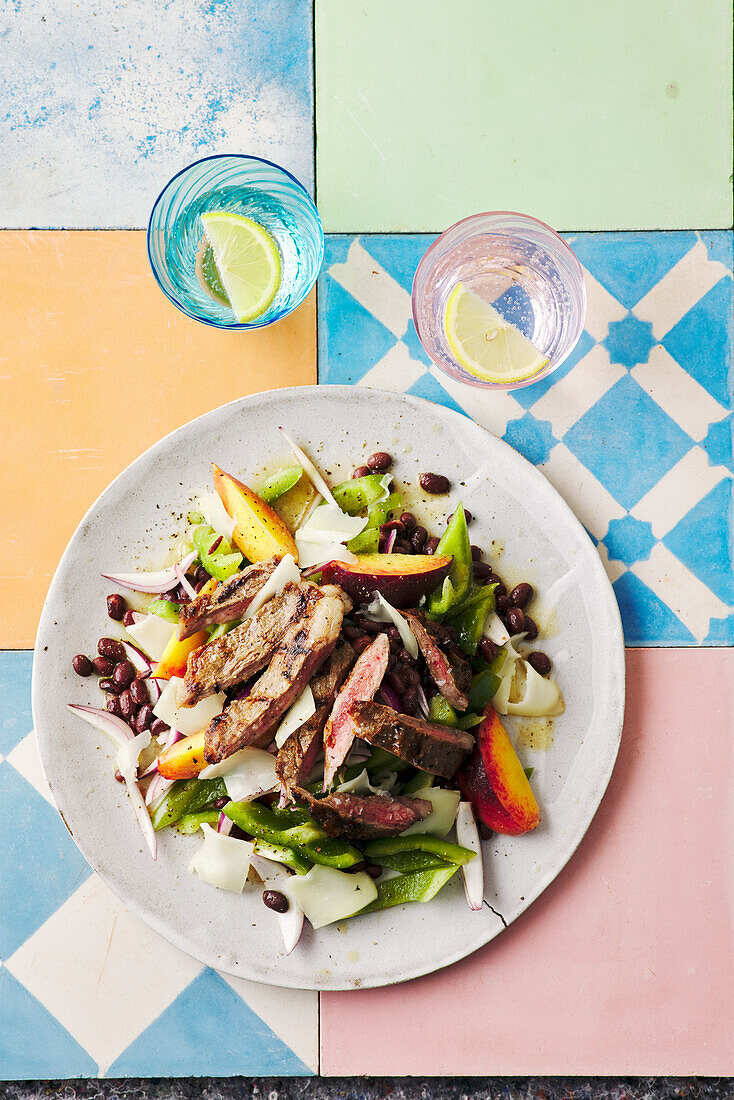 Salad with grilled Secreto, peach, black beans and goat's cheese