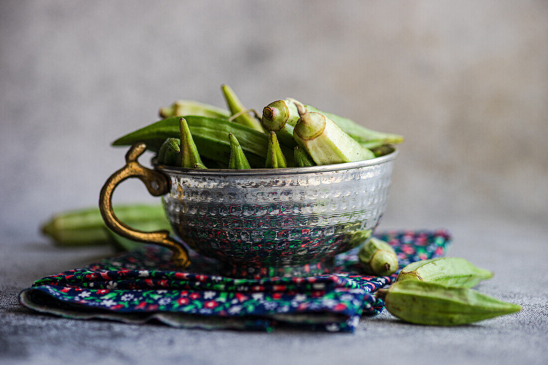 Fresh okra pods in metal bowl