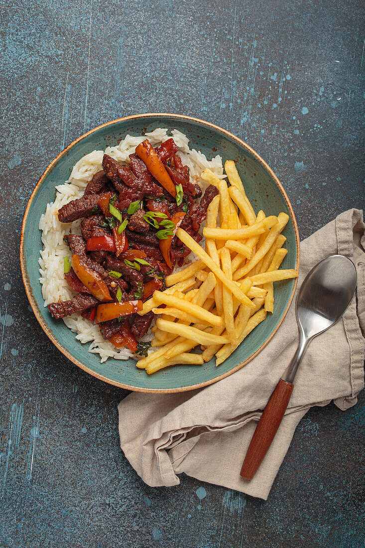 Peruanisches "Lomo Saltado" mit Rindfleisch, Pommes, Reis und Gemüse