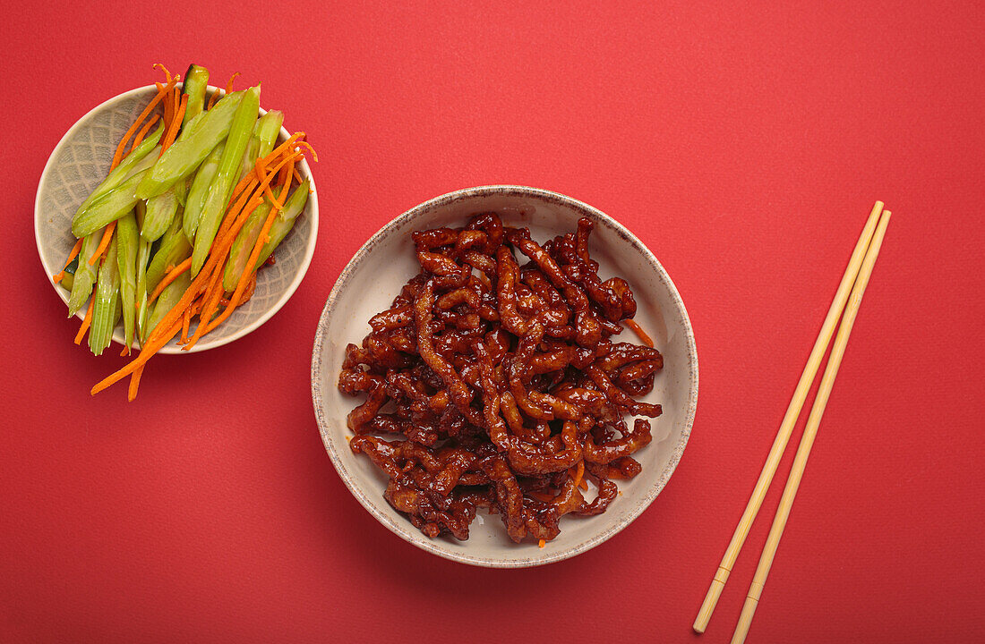 Sweet and sour pork with celery and carrot strips