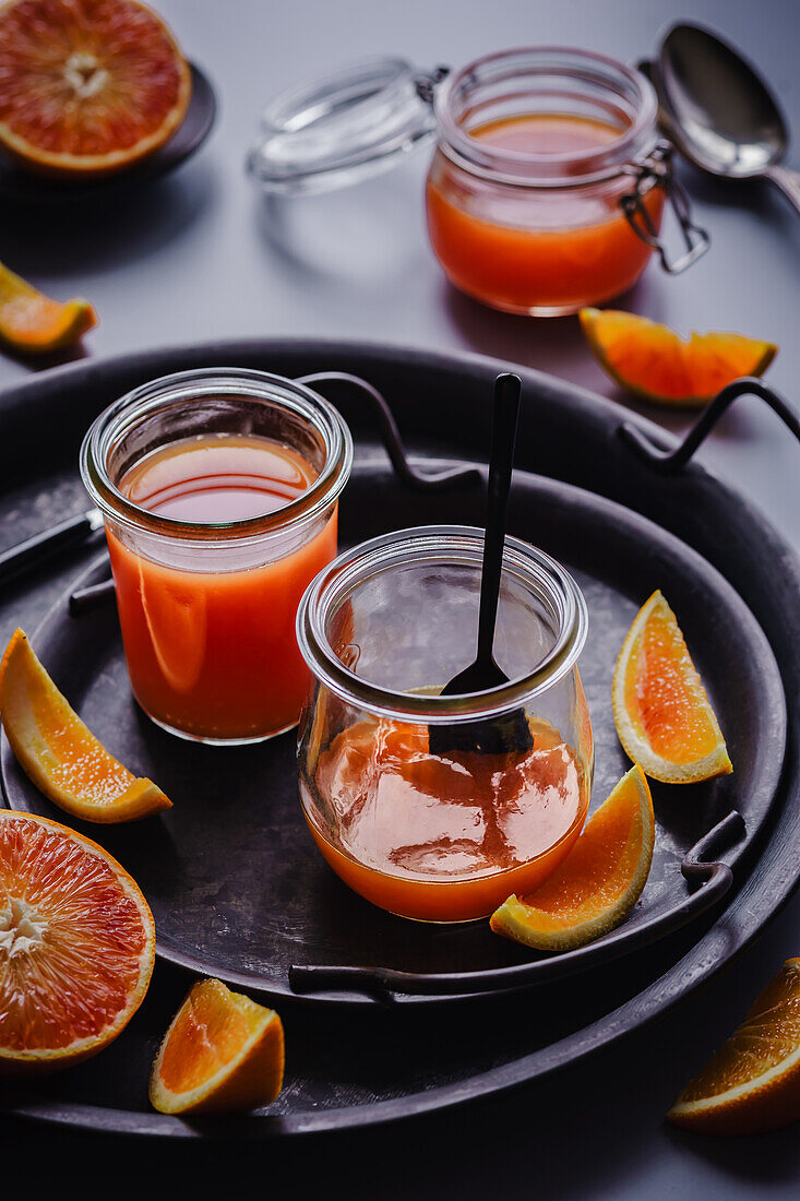 Frisch gekochtes Orangengelee in Gläsern mit Orangenspalten