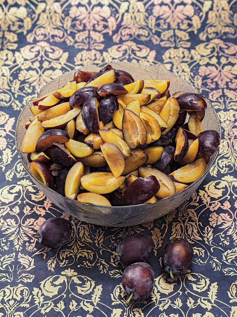 Bowl of fresh and sliced plums