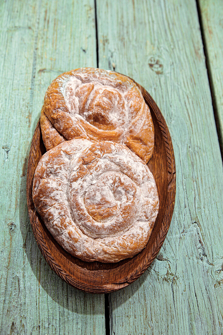 Two ensaïmadas on a rustic wooden board