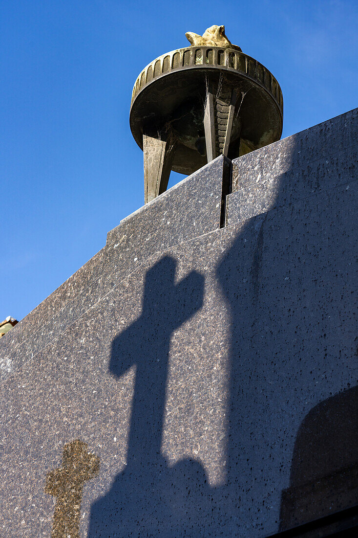 Eternal flame & shadow of a cross on the mausoleum of Eva "Evita" Peron, Recoleta Cemetery, Buenos Aires, Argentina.