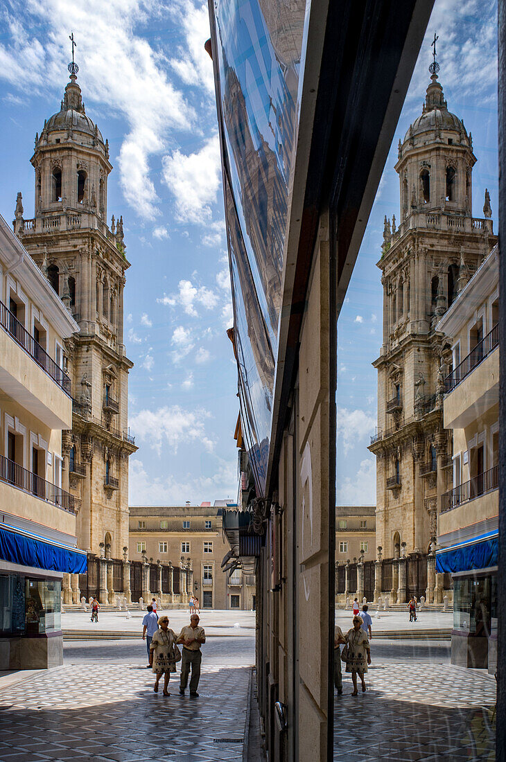 Eine beeindruckende Spiegelung eines der Türme der Kathedrale von Jaen in einem Schaufenster, die die architektonische Eleganz dieser historischen Stätte in Andalusien, Spanien, unterstreicht