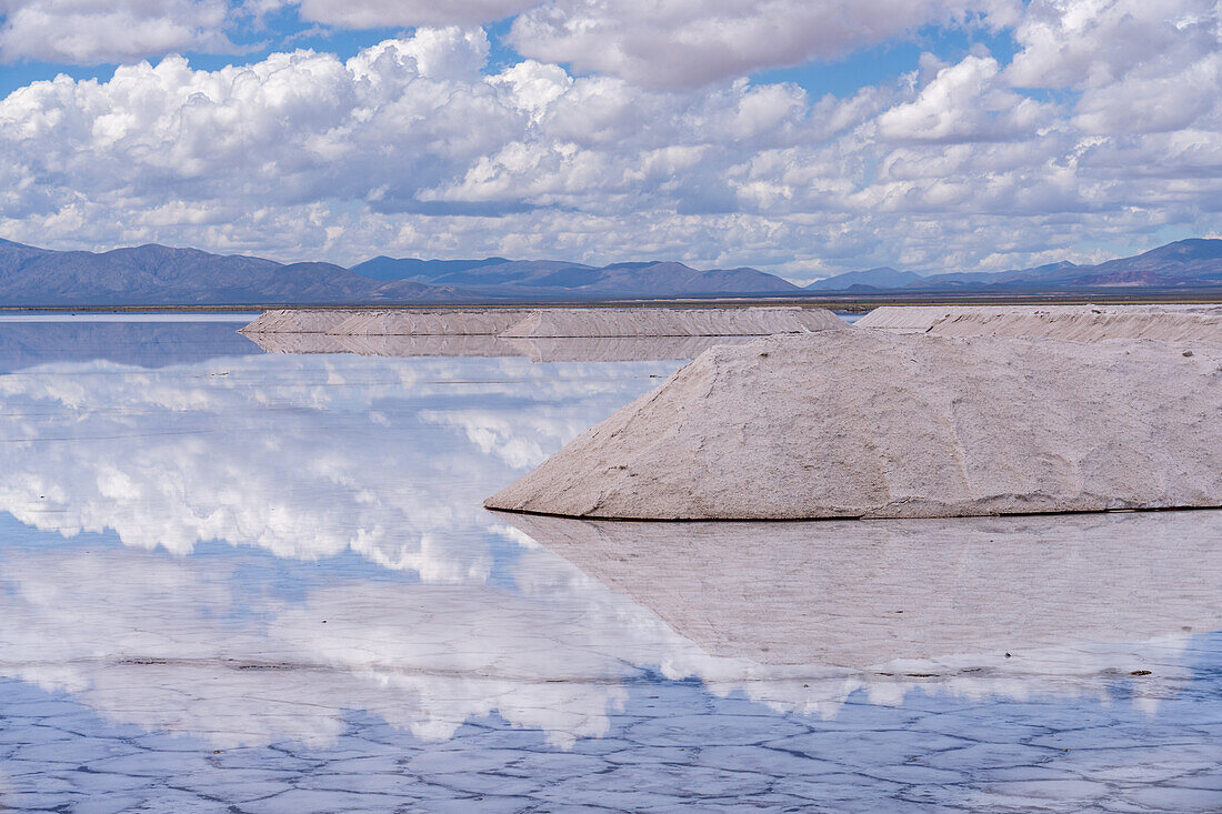 Salzabbau in den Salinen von Salinas Grandes im Nordwesten Argentiniens. Die Wolken spiegeln sich auf einer flachen Wasserfläche