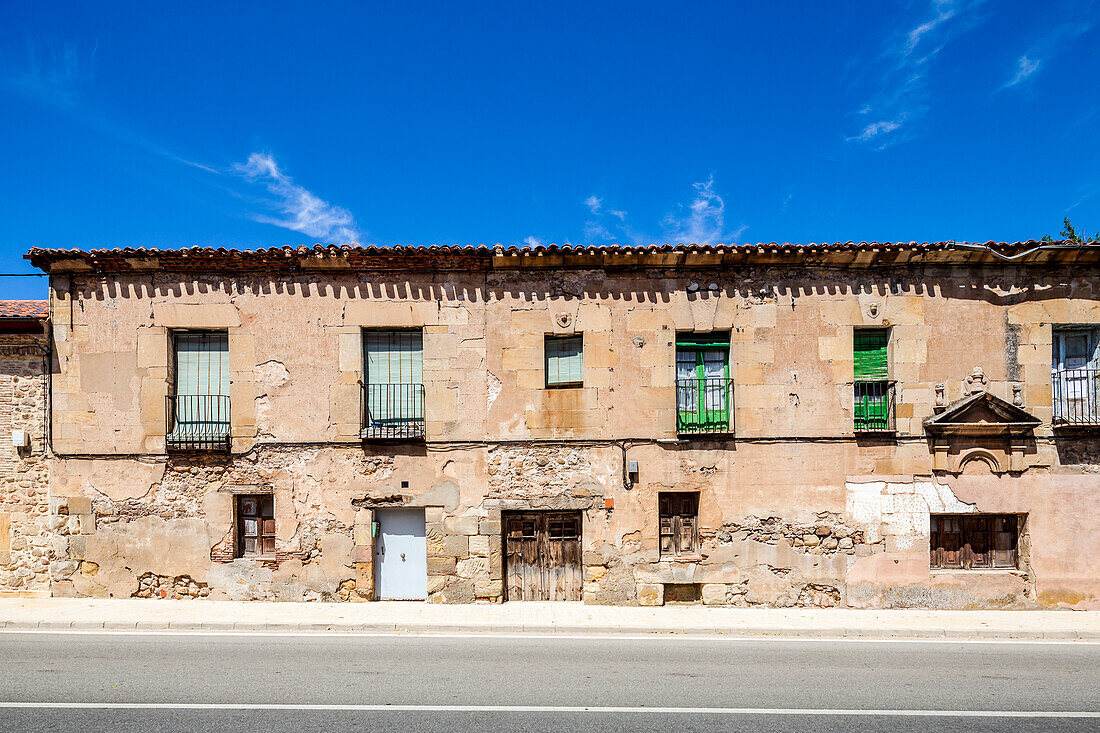 A row of old, stone houses in Soria, Spain, with windows and doors.