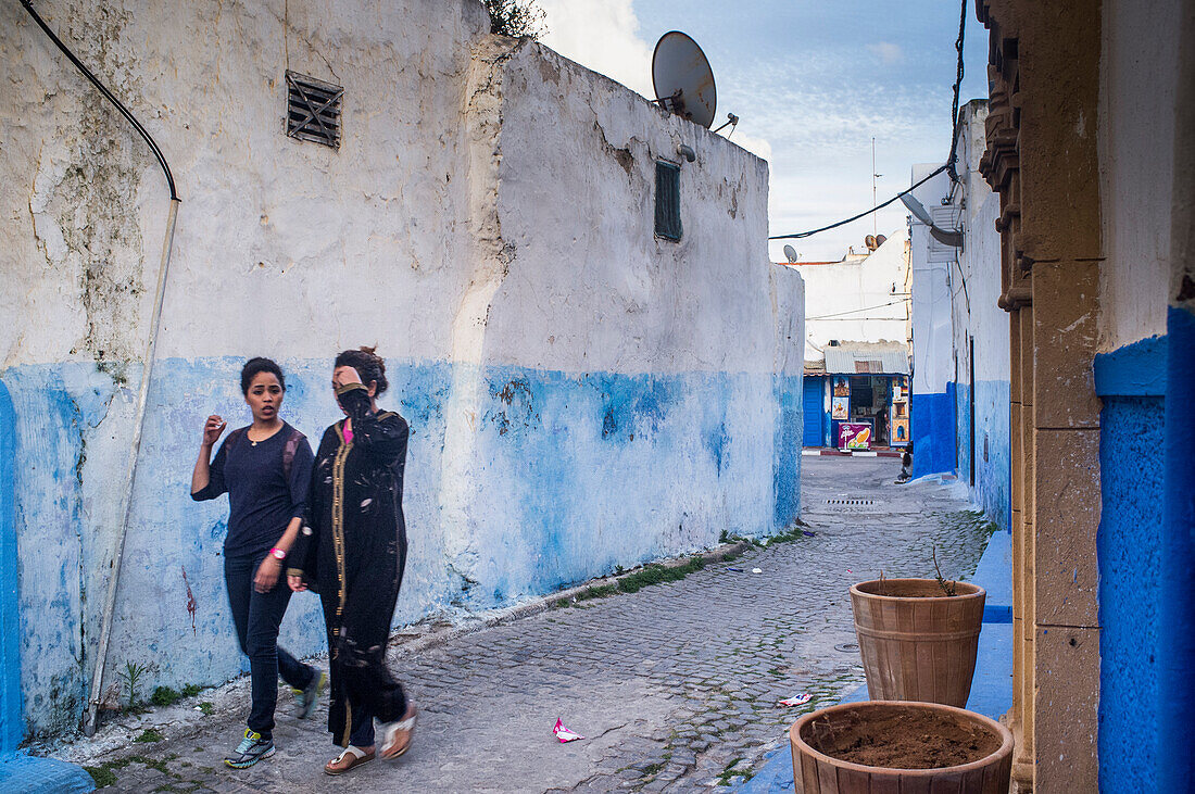 Rabat, Marokko, 24. April 2015, Zwei Frauen schlendern durch die farbenfrohen blauen und weißen Gassen der historischen Kasbah der Udayas in Rabat, Marokko, und genießen die lebhafte Atmosphäre