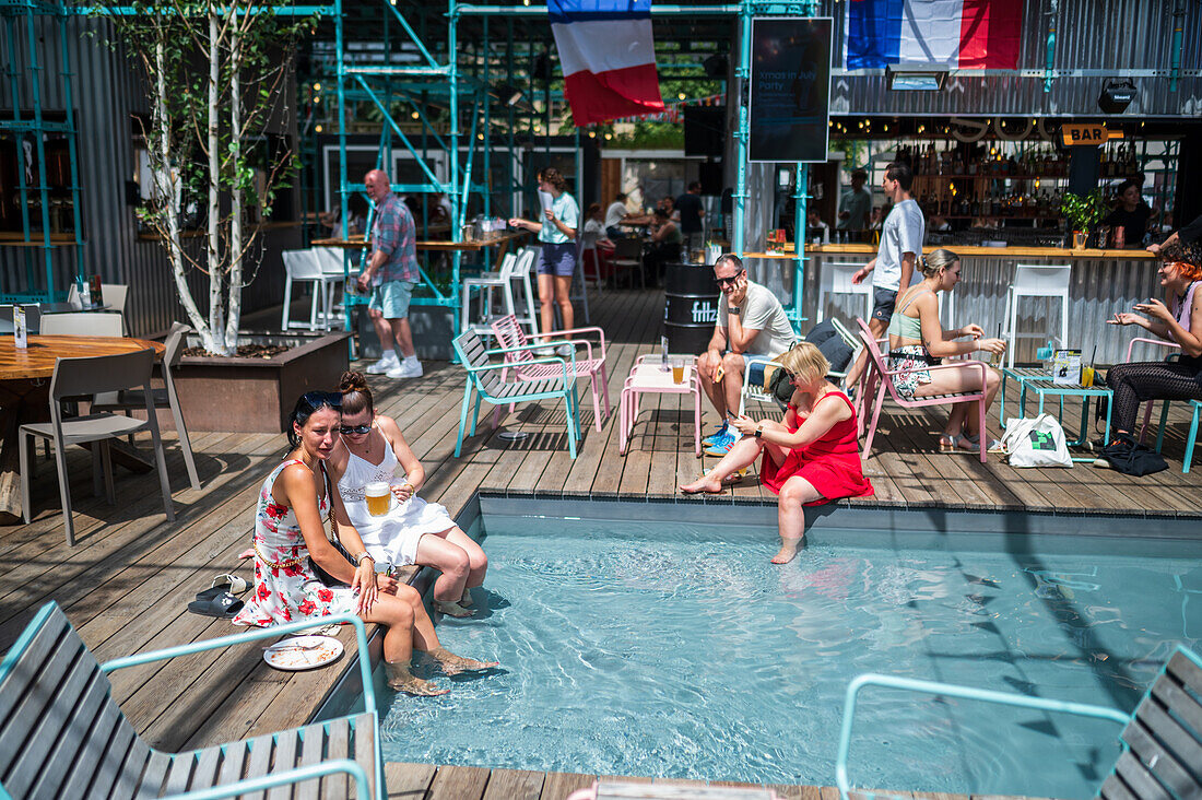 Clients refresh by the pool at Manifesto Market, a must-visit cultural experience in the heart of Prague with pop-up design retail experience bars and high-quality street food.