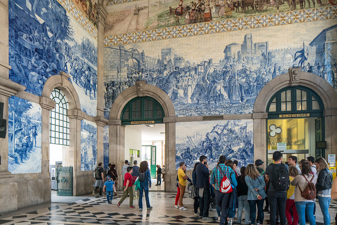 Porto, Portugal, 15. April 2017, Touristen bewundern die atemberaubenden Azulejos am Bahnhof Sao Bento in Porto, Portugal. Dieses ikonische Kunstwerk stellt wunderschöne historische Szenen dar und ist ein Muss für Besucher