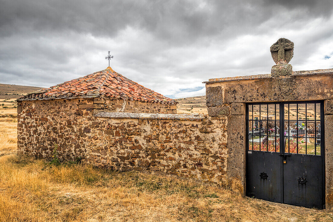 The Cemetery of Gallinero in Almarza features a rustic chapel surrounded by picturesque landscapes and historical stone walls, evoking tranquility.