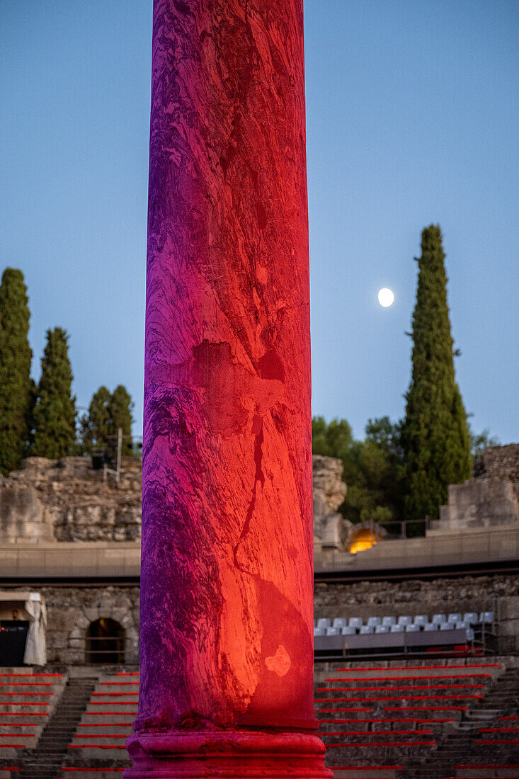 Merida, Spain, Aug 15 2024, A vibrant light display illuminates a Roman column at the historic Merida Roman Theatre in Spain, showcasing its architectural beauty under a serene night sky.