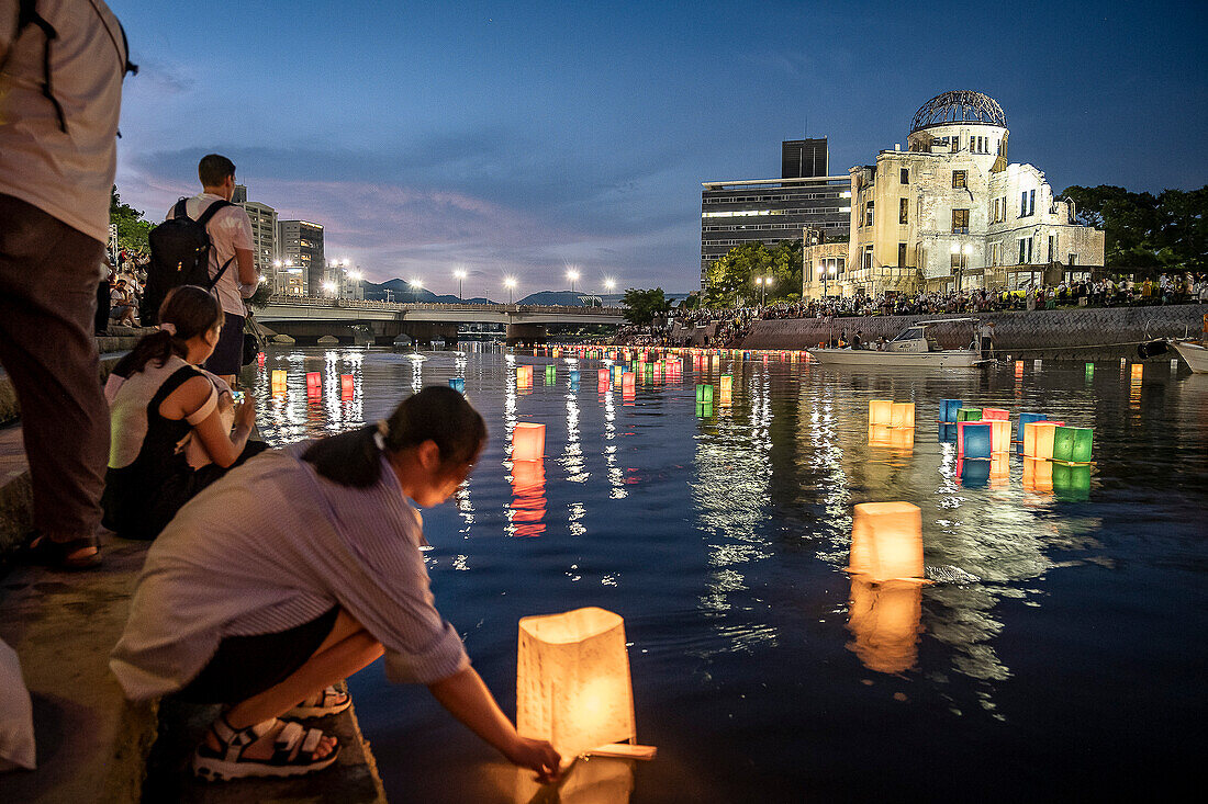 People float lanterns on the river, in front of Atomic Bomb Dome with floating lamps on Motoyasu-gawa River during Peace Memorial Ceremony every August 6 in Hiroshima, Japan