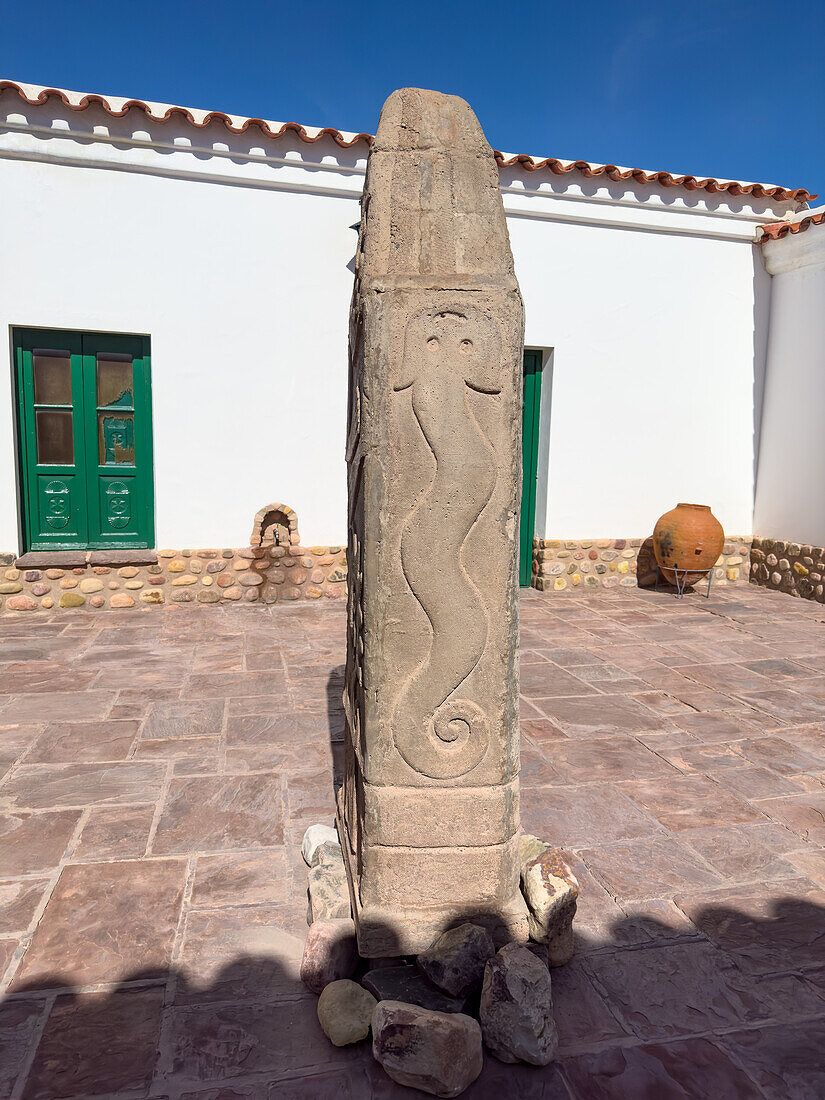 A carved bas relief monolith in the courtyard of the Dr. Eduardo Casanova Archeology Museum in Tilcara, Argentina.