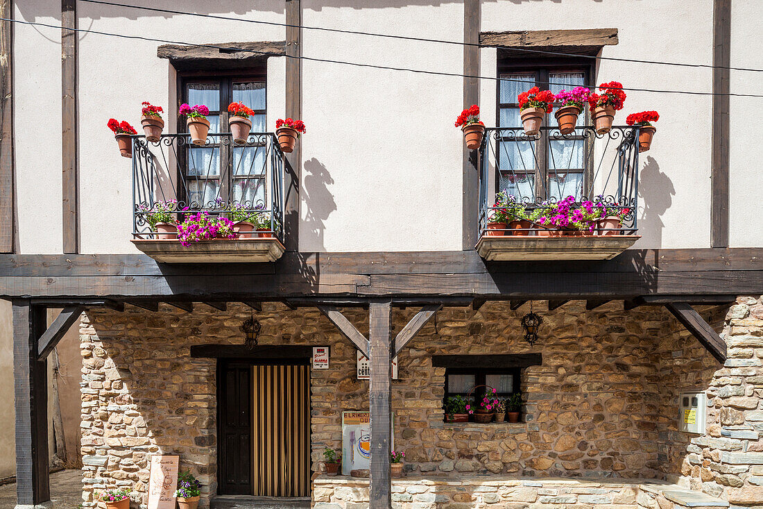 A typical house in Yanguas features colorful flower boxes that enhance its rustic charm, showcasing the architectural beauty of Soria, Spain.