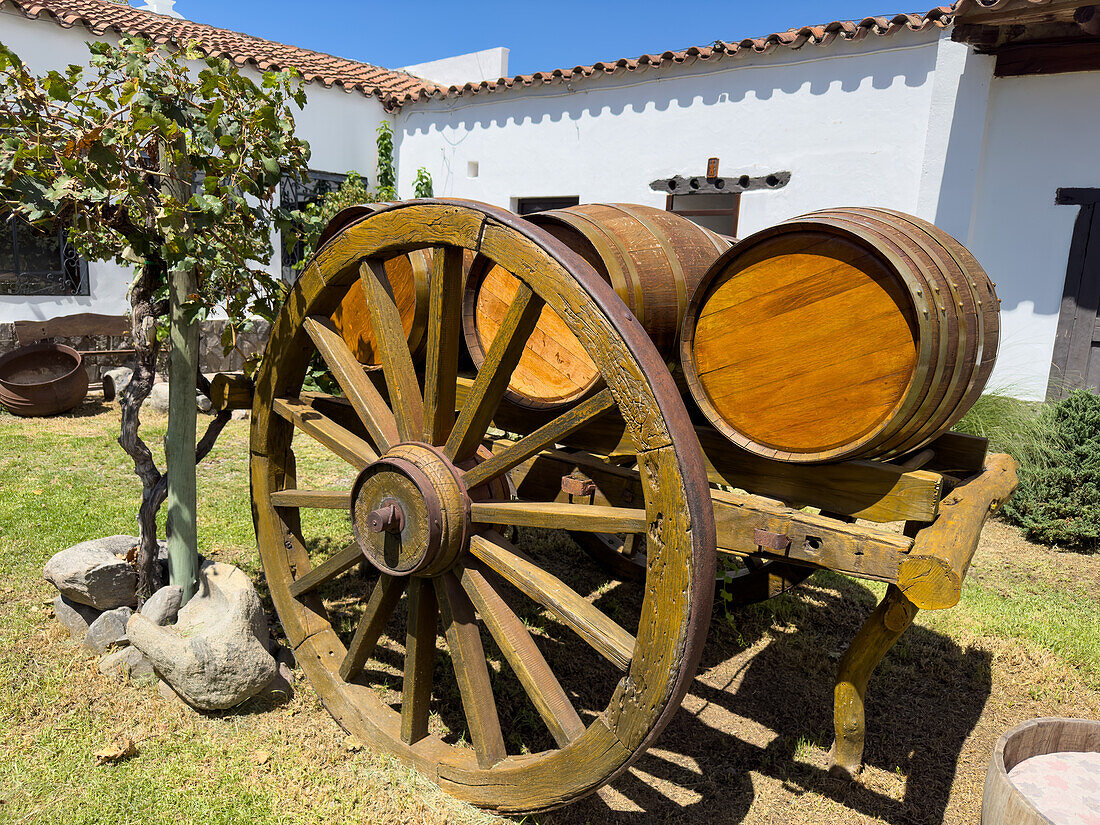 Ein Holzkarren mit Weinfässern als Dekoration im Innenhof der Bodega Nanni Winery, Cafayete, Argentinien