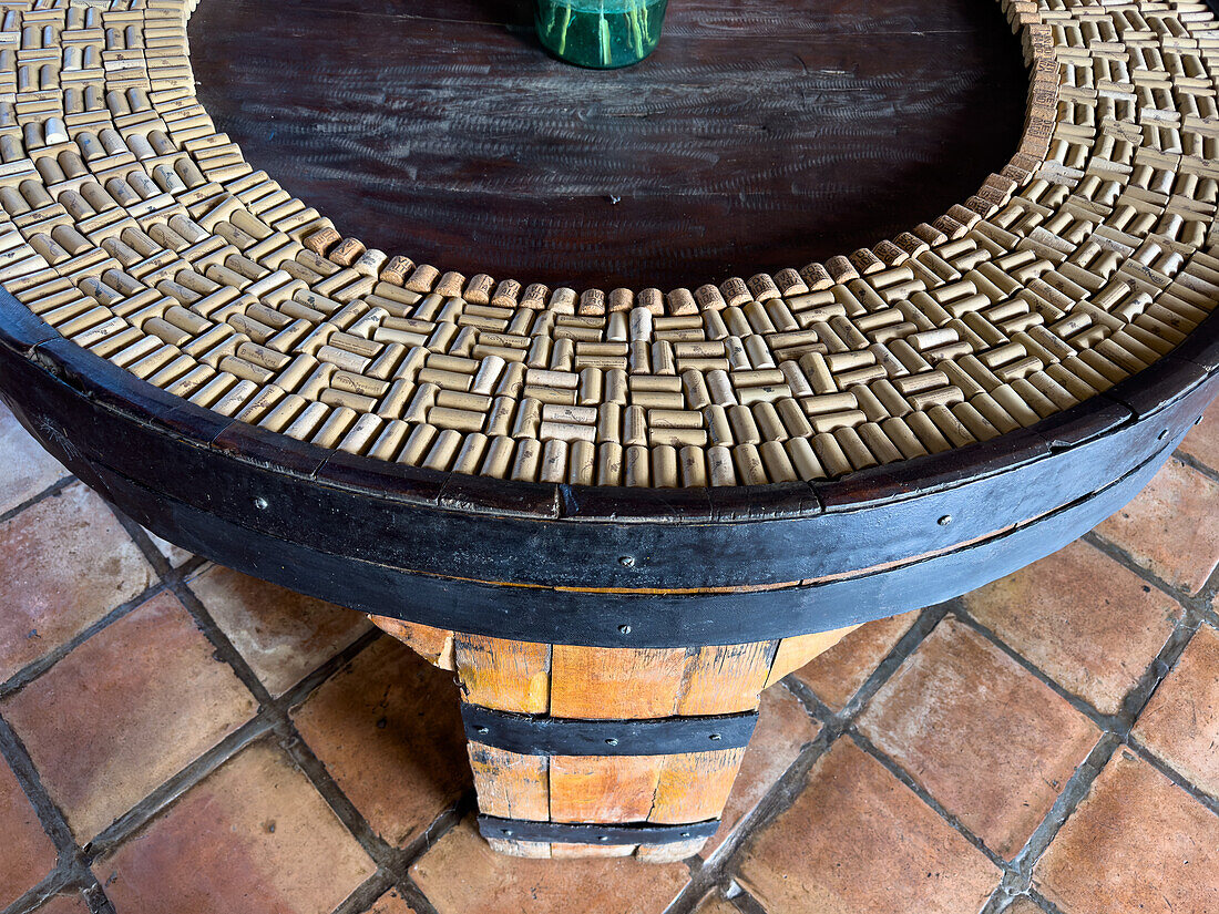 A table made from a wine cask with a decorative design made of wine bottle corks. Bodega Nanni, Cafayete, Argentina.